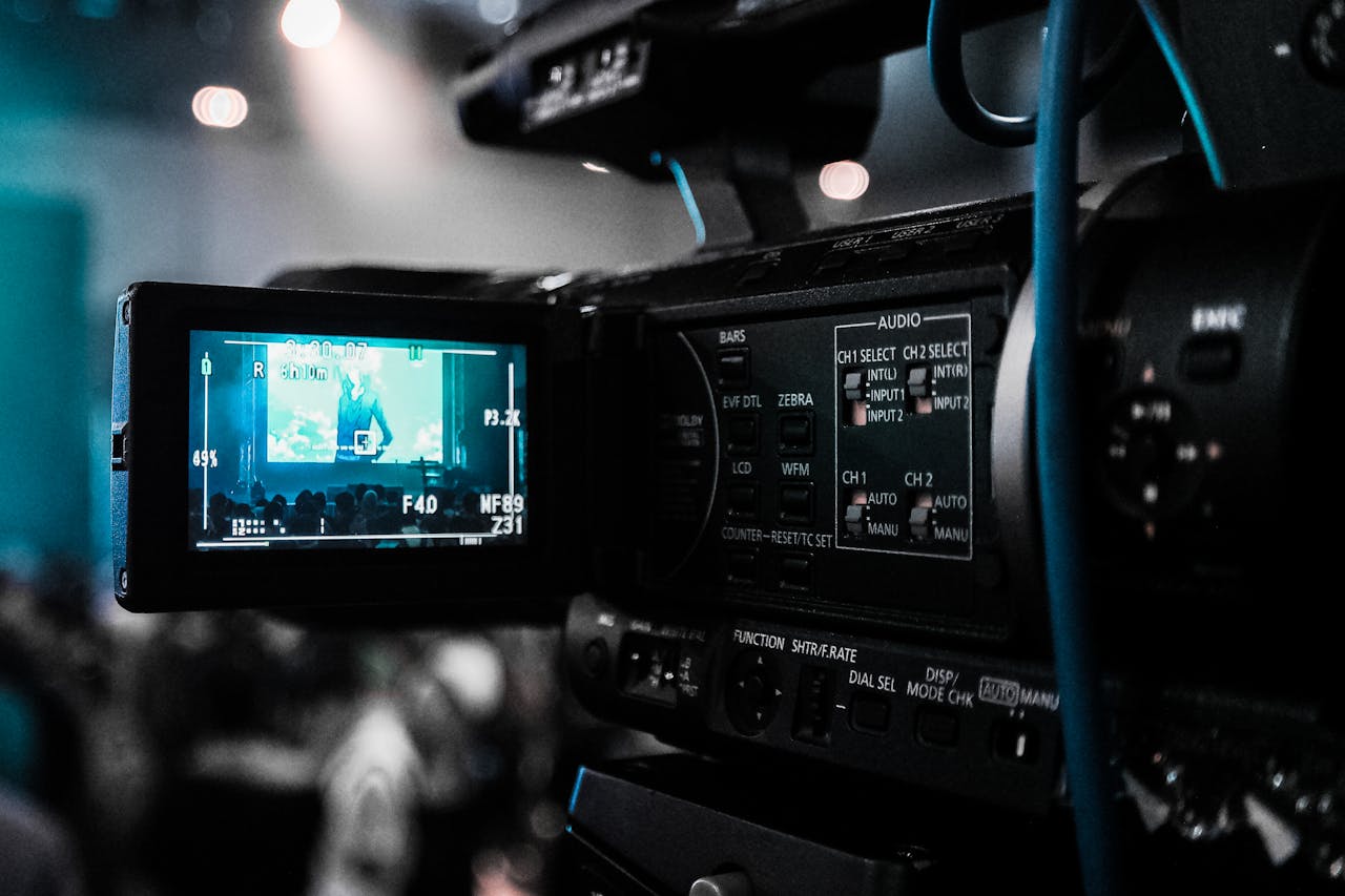 my-qualifications HD video camera capturing a live event; focus on screen and controls.
