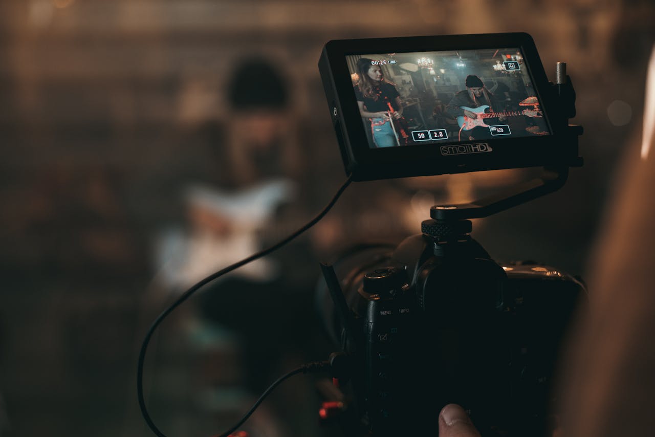 service-03 A cinematic close-up of filming a rock band performance with focus on camera screen.